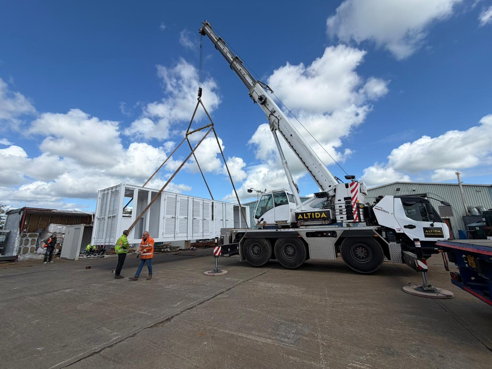 An Altida crane lifting a section on a spreader beam at an energy-storage site in Sheffield, the units alongside